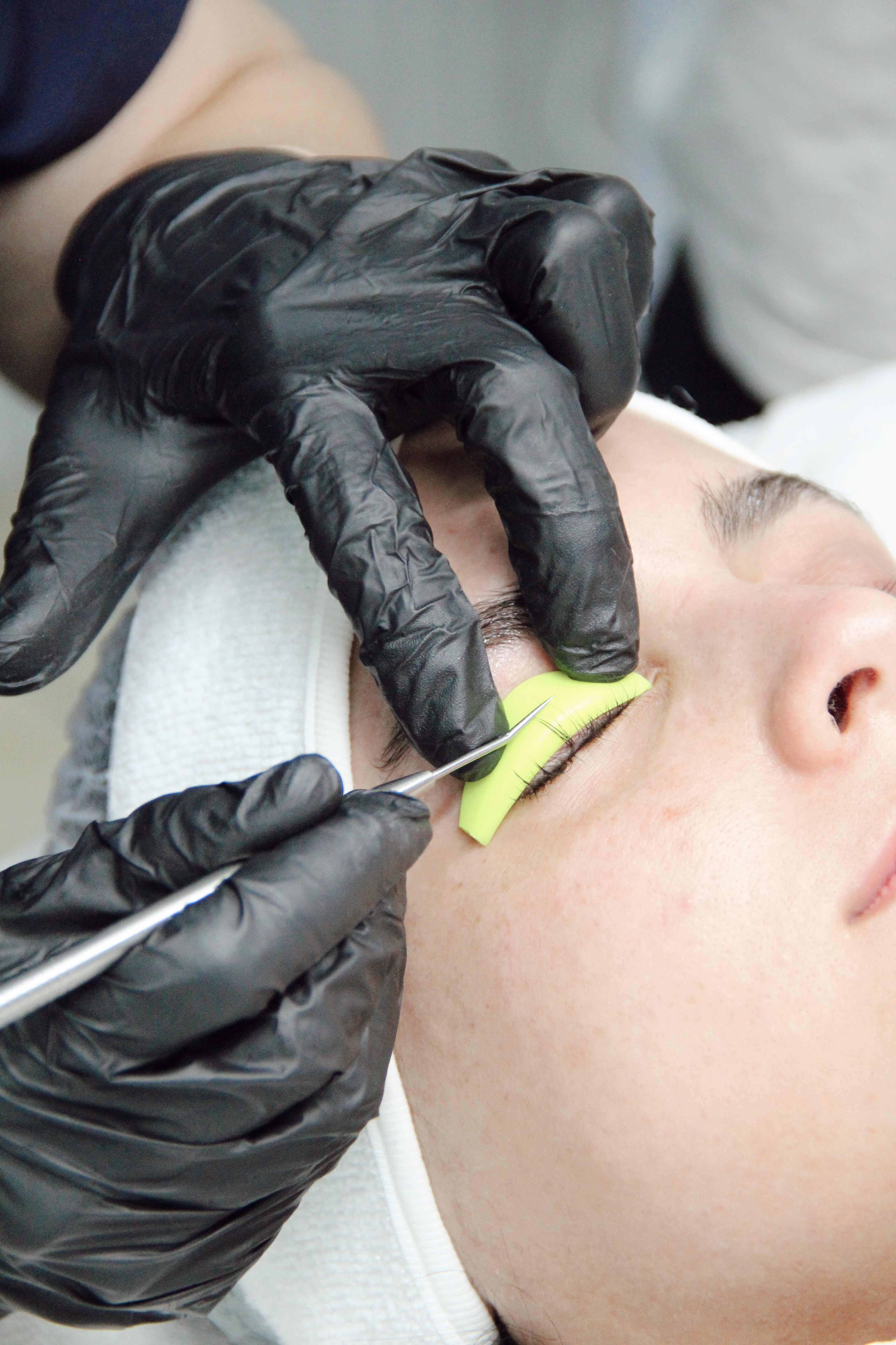 Proceso profesional de perfilado de cejas con pinzas especializadas en Glenz Studio